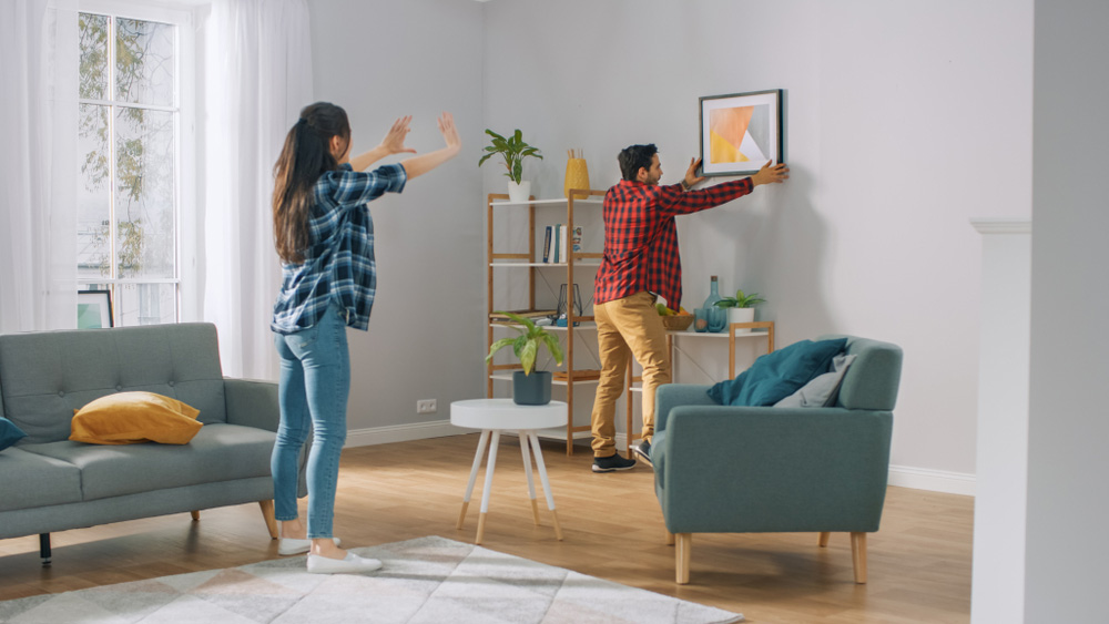 Couple setting up decor in their new home