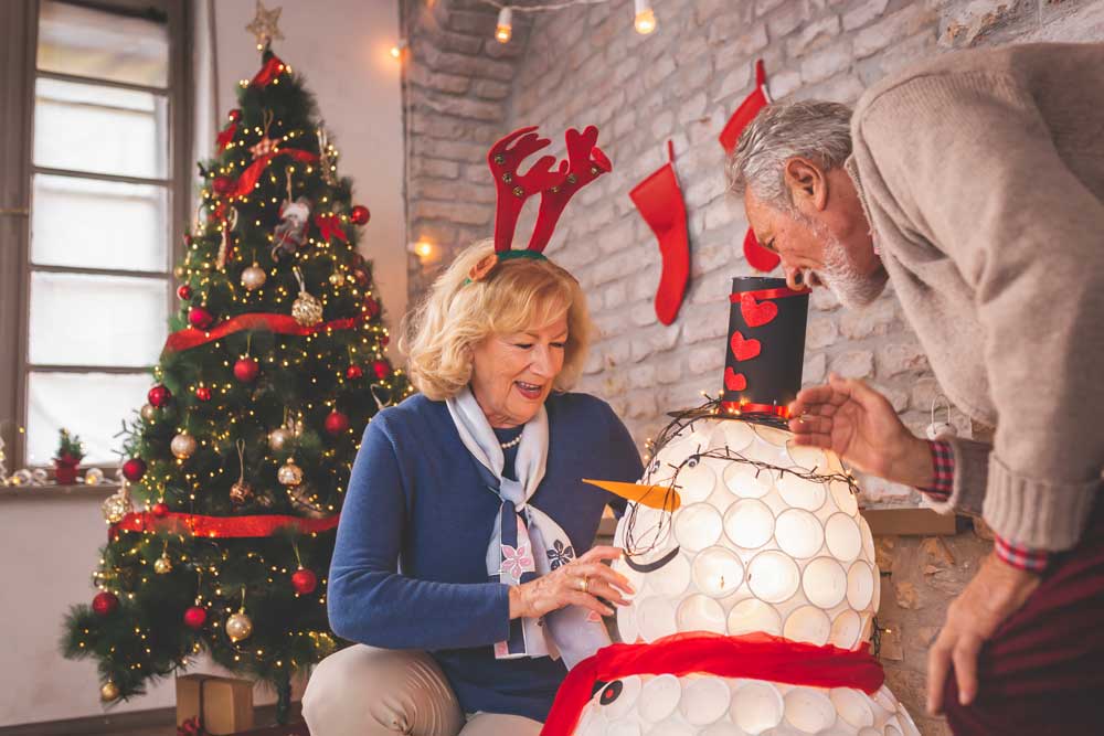 family decorating home with christmas statues