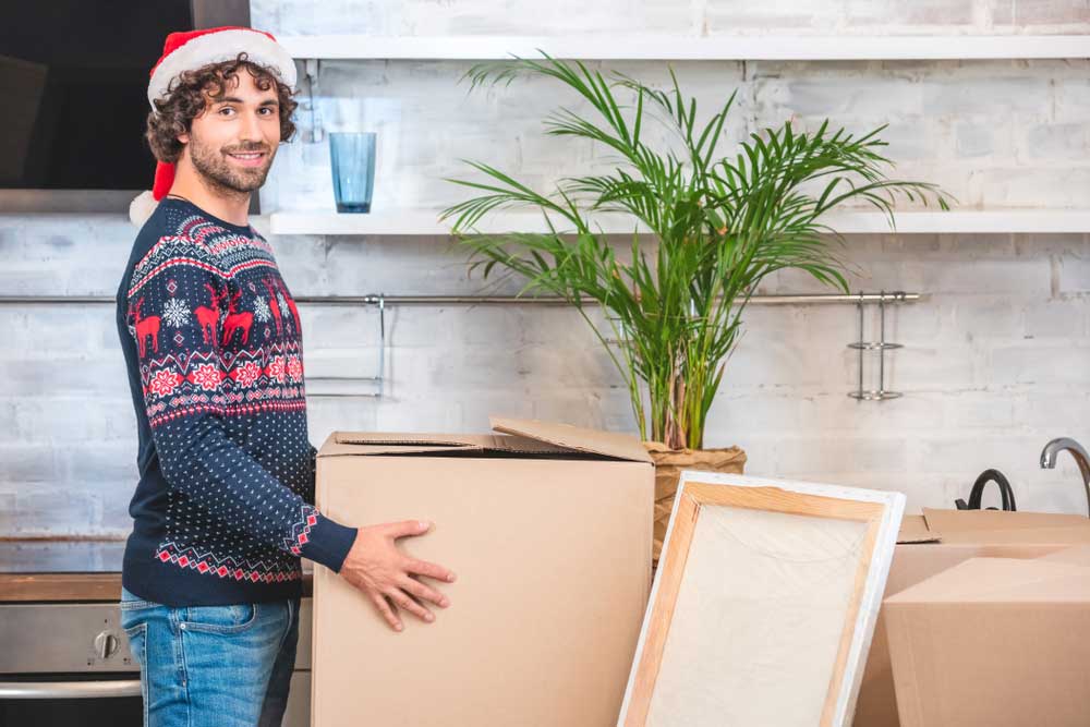 young man organizing moving boxes around home